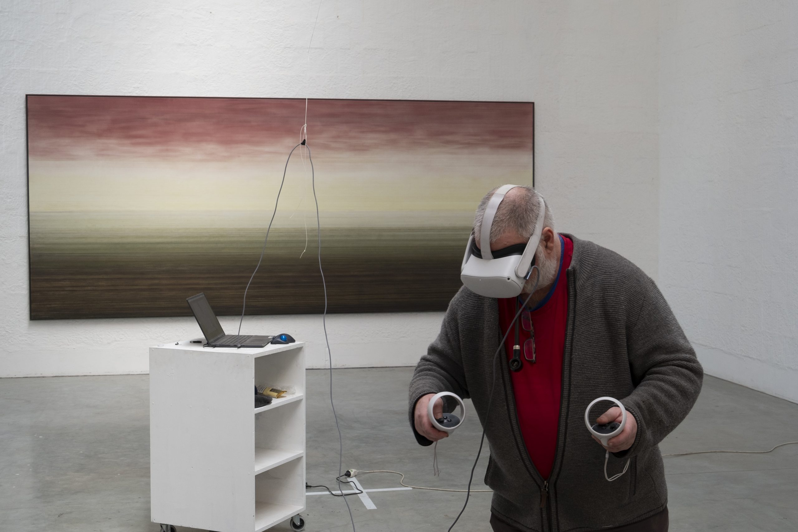 artist wearing virtual reality glasses and using joysticks to paint sculpture