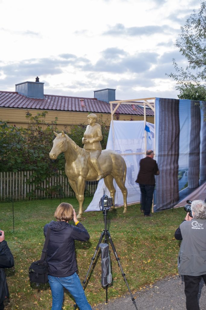 uncovering of 3d printed angela merkel equestrian statue during opening at museum