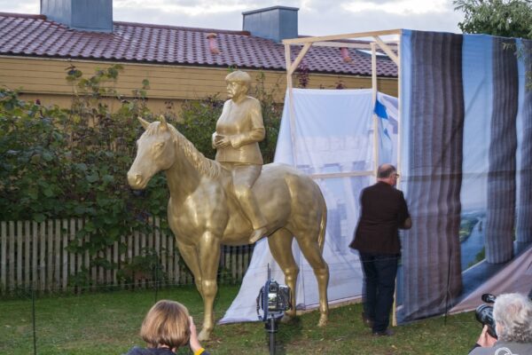 uncovering of 3d printed angela merkel equestrian statue during opening at museum